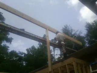 Carpenter setting a ridge beam over a new addition frame — Ice Dam Removal by Roofing Brothers in Fairburn