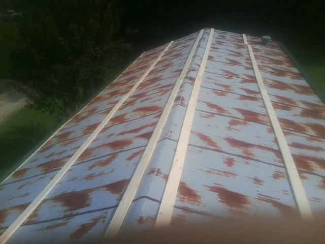 Rusted metal roof panels with new wood purlins before replacement — Storm Damage Roof Repair in Fairburn by Roofing Brothers