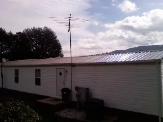 New metal roof on a single wide mobile home with a TV antenna in Fairburn