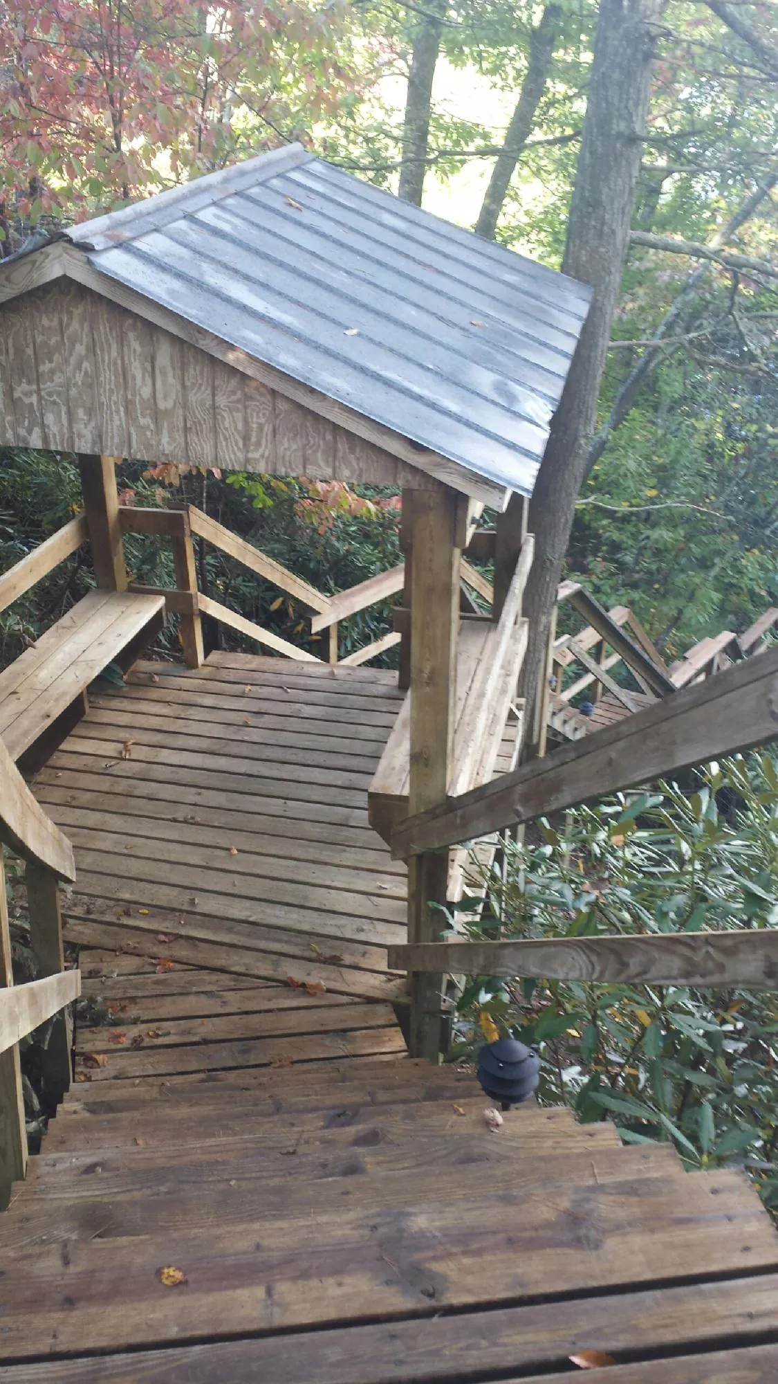 Metal roofed shelter over wooden steps on a wooded walkway — Skylight Repair & Installation work by our crew in Fairburn