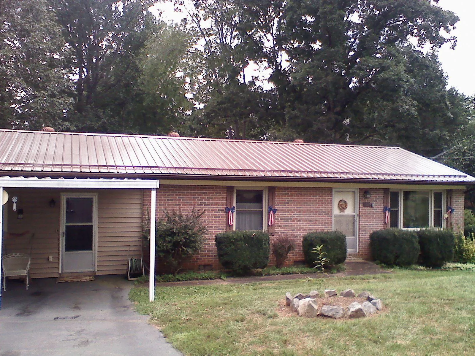 Bronze metal roof and carport on a brick ranch home — Roof Repair work by our crew in Fairburn